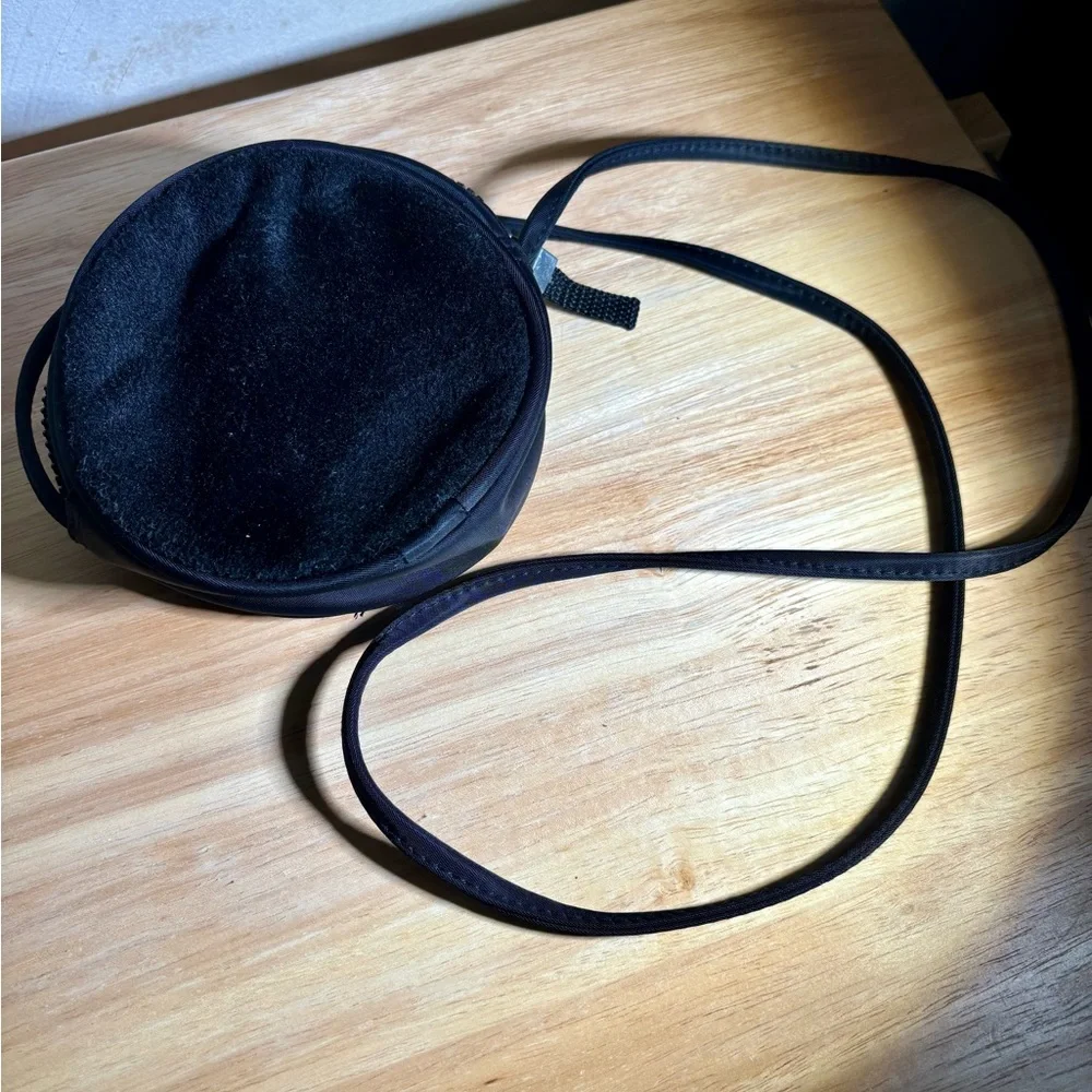 Women’s Round Black Crossbody Bag with zipper closure.